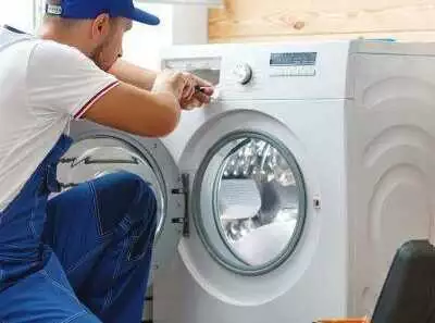 Repairman fixing a washing machine.
