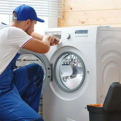 Washing Machine Repair Services 1 Repairman fixing a washing machine.