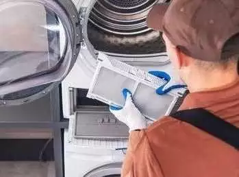 Technician cleaning dryer lint filter.