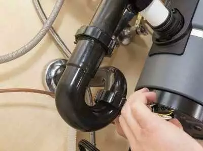 Hand connecting garbage disposal plumbing