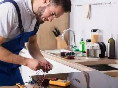 Technician repairing kitchen appliance.