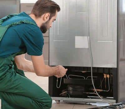 Technician repairing a refrigerator unit.